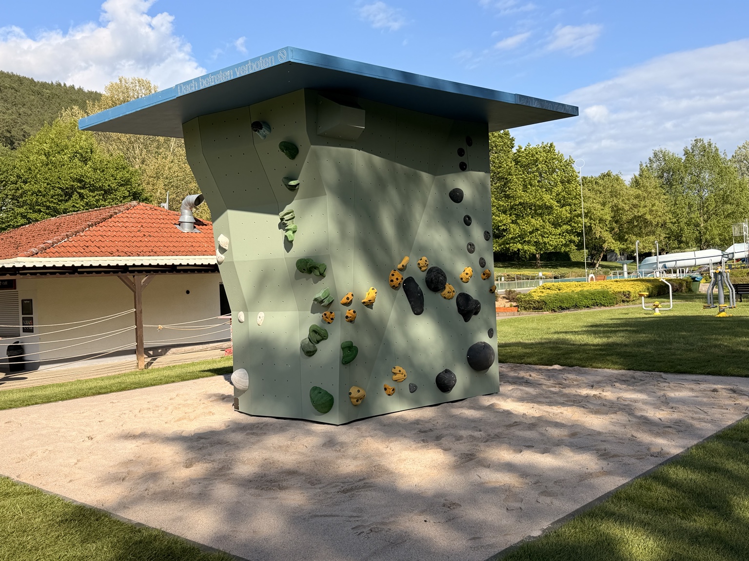 Freistehender Outdoor-Boulderturm mit farbigen Klettergriffen